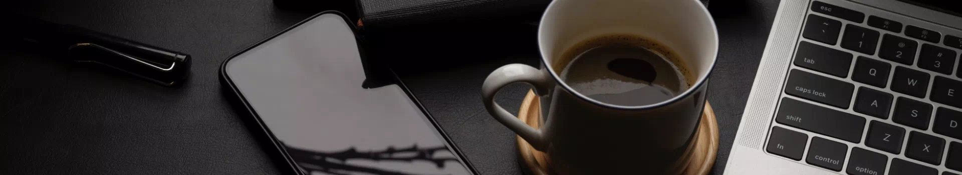 Telefon i laptop obok kawy